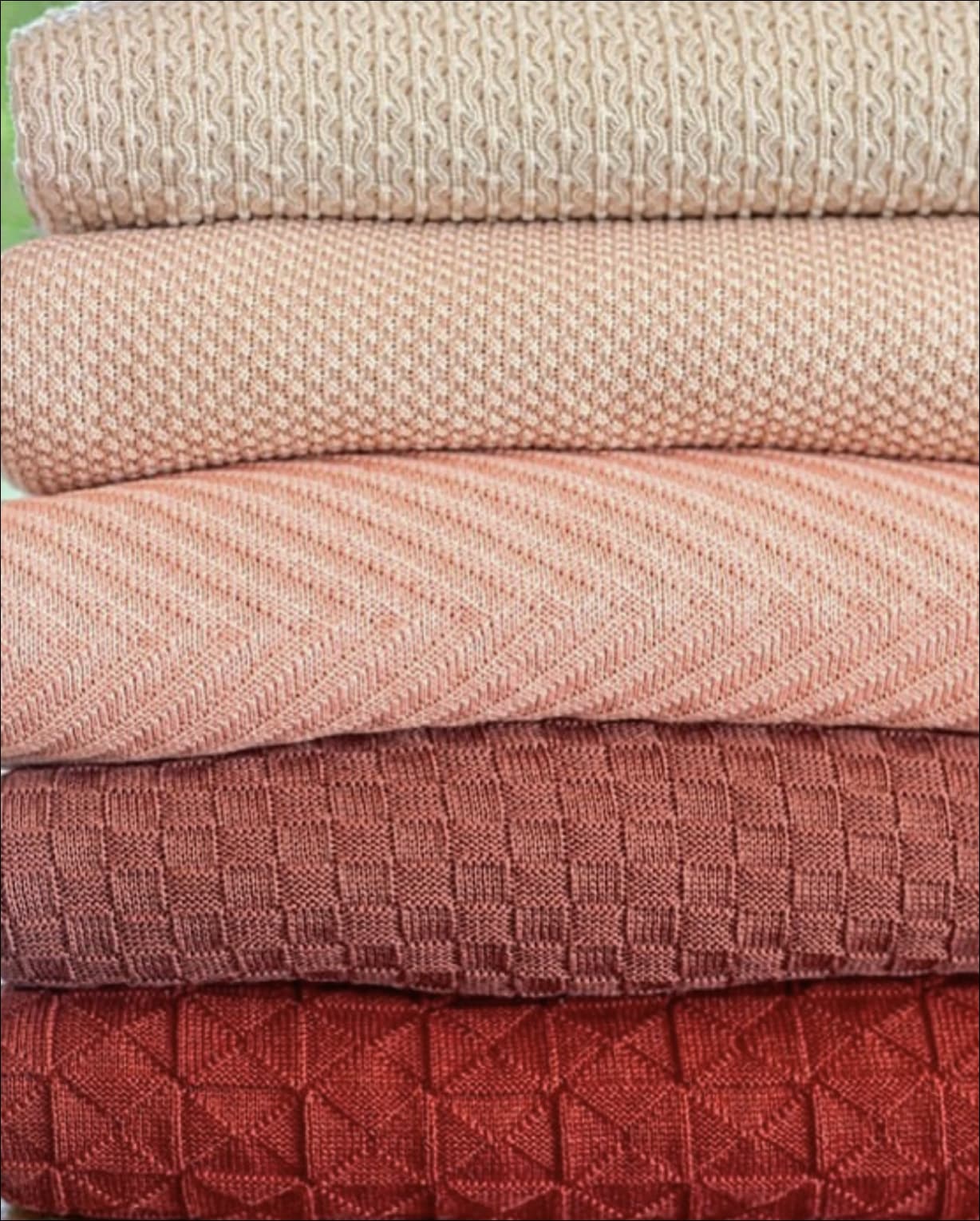 Stacked quilts in pink and terracotta tones