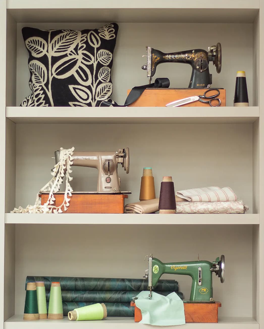 Atelier shelves with vintage sewing machines, threads and fabrics